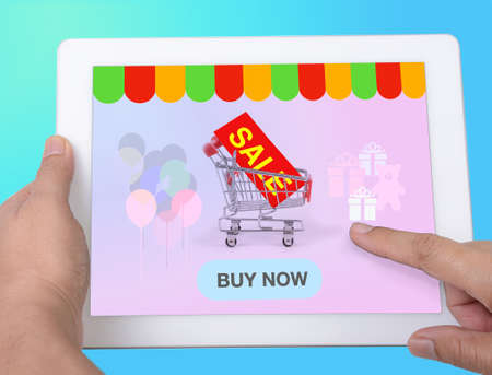 Hand holding electronic tablet to searching for discount sale by online shopping application.