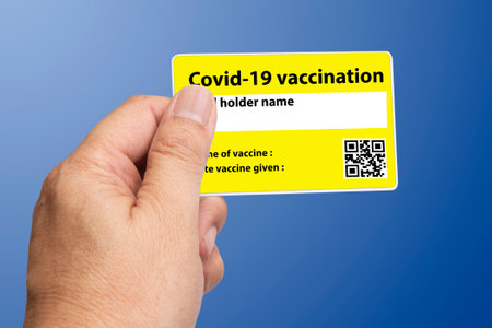 A person showing covid-19 vaccineation card in hand.の写真素材