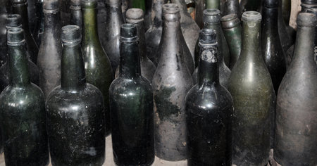 Lined with various old green glass bottles looking dirty and dusty.の写真素材