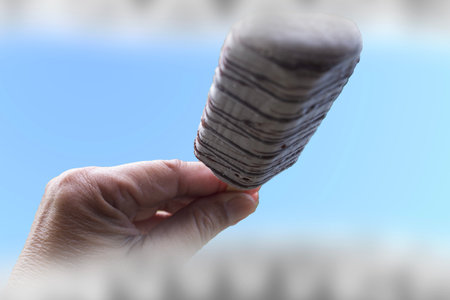 View from inside the mouth of someone holding an ice cream stick and preparing to eat it.の写真素材
