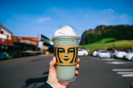 Jeju Island, South Korea - July 10, 2022: Jeju Mugwort rice cake Frappuccino with wripcream on hand.のeditorial素材