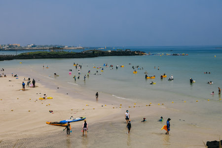 Jeju Island, South Korea - July 10, 2022: Many people are splash at hamdeok beach in summer, Jeju Island, South Korea.のeditorial素材