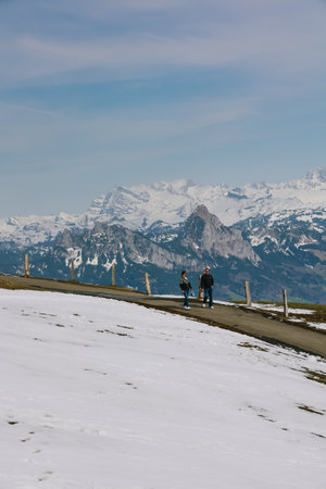 Rigi, Switzerland - April 12, 2022: People walking to the view point at Rigi Kulm with alps mountain...