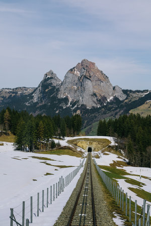 Tracks of steepest funicular at mountain village Stoos on a sunny spring day arriving at mountain station.の写真素材