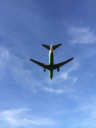 Flying airplane in a blue sky の素材