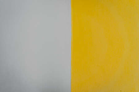 Pictures of gray and yellow cement walls with a smooth and clean surface. There is a dividing line in the middle in a soft tone. The idea for two-color backgrounds. There is a copy space.の写真素材