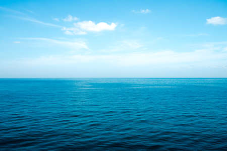The front view in the morning sky is bright blue with clear white clouds. And the ocean deep indigo in daylight feeling calm, cool, relaxing. The idea for cold background and copy space on the top.の写真素材