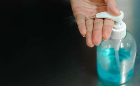 The white woman's hand is pressing liquid alcohol pump bottle with a splash on the palm to clean the hands and prevent infectious diseases. Concepts in preventing epidemics of COVID-19 or Coronavirus.の写真素材