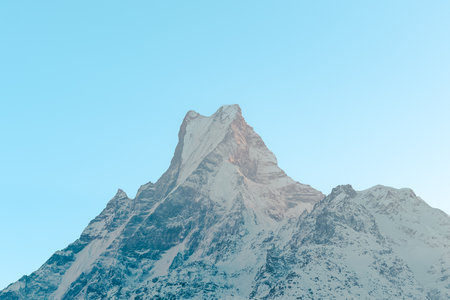 The front view of the Machapuchare peak is covered by snow on top in winter, Mardi Himal trek, Nepal. Clear sky on a sunny and chilly day. The idea for a soft-toned nature background with copy space.の写真素材