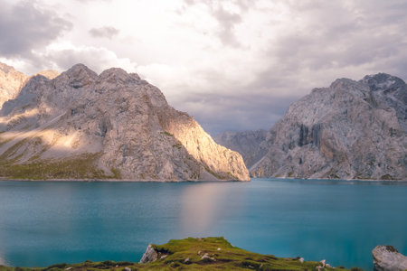 The front view of Tientang Hu lake, Xinjiang, China. There are many mountains behind. The sun was setting with soft light. There is a lush green lawn. The idea for Trekking wallpaper with copy space.の写真素材