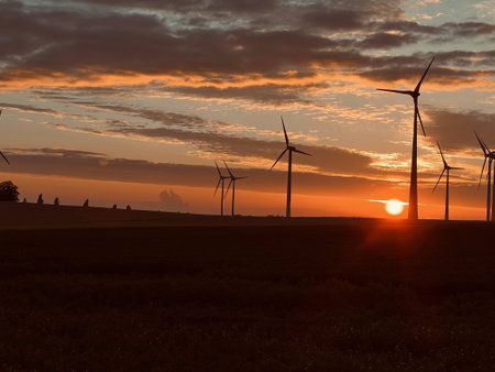 An image of wind turbines in the field at sunset.の写真素材