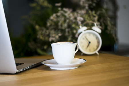 working desk with a cup of coffee and notebook.の写真素材