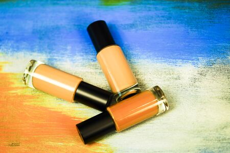 Bottle of liquid foundation on colorful background.