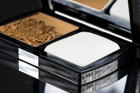 Brown color of compact foundation powder in black packaging.の写真素材