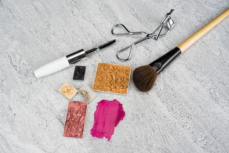 Pink lipstick and lipstick smear on stone texture background./ Lipstick