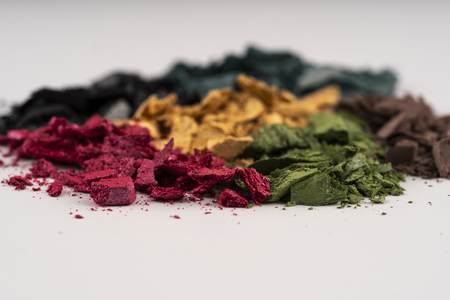 Pink, green, gold, blue, beige color of eyeshadow powder on white backgroundの写真素材