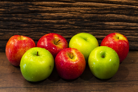 Fresh red and green apples on wooden backgroundの写真素材