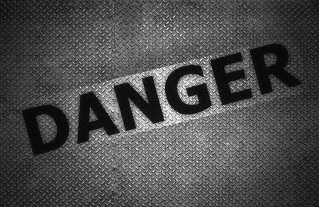Steel plate background with danger text, Black and white.の写真素材
