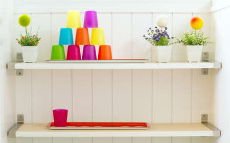 Plastic color cup on white shelfの写真素材