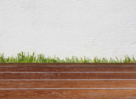 White concret wall and green grass on wood floorの写真素材