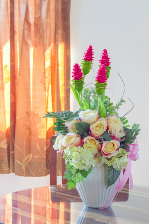 Beautiful Fake Flowers in Whie pot on wood table, cool toneの写真素材
