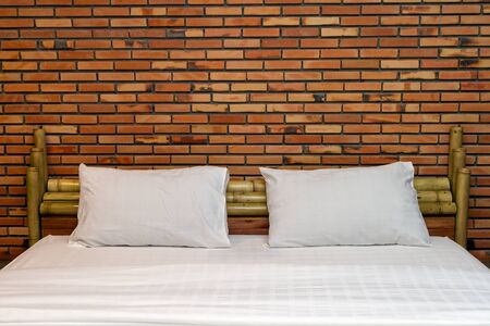 Empty bed with brown brick wallの写真素材