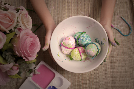 painted fake eggs in white dish, retro color style. Easter still lifeの写真素材