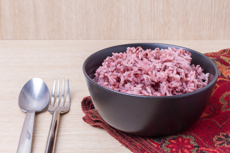 cooked jasmine rice mixed rice berry in black blow on red clothの写真素材