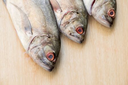 Close up Group of Fresh sea fish on wooden tableの写真素材