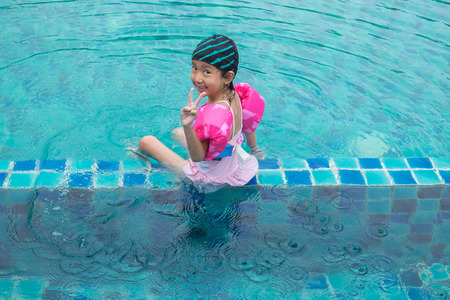 Happy little girl plaing in swimming pool