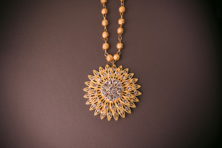 Low key of shiny gold jewelry on Brown leather.