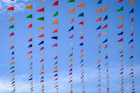colorful bunting flags against a blue sky background.の写真素材