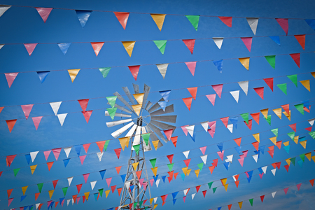 colorful bunting flags against a blue sky background.の写真素材