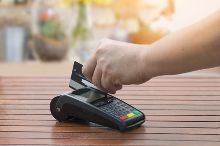Close up a man using EDC machine for credit card at cashier counterの写真素材