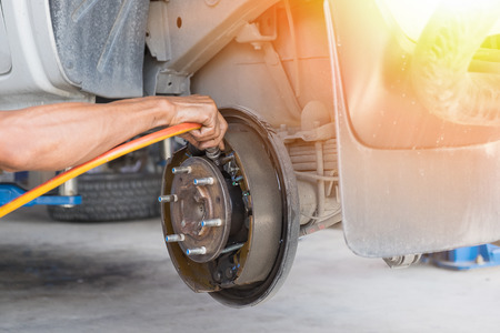 A man cleaning the brake drum with air tube.の写真素材