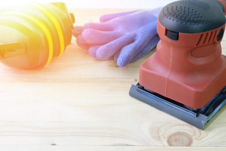 Close up orbital sander machine with protection equipment on wooden.の写真素材