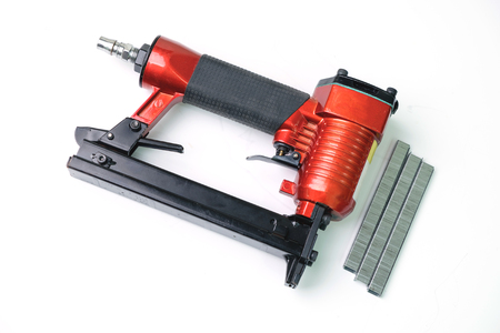 Close up pneumatic nailer gun on white background.の写真素材