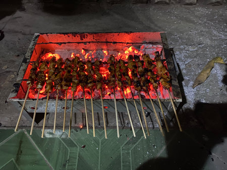 Grilling chicken satay with a charcoal fire.の写真素材
