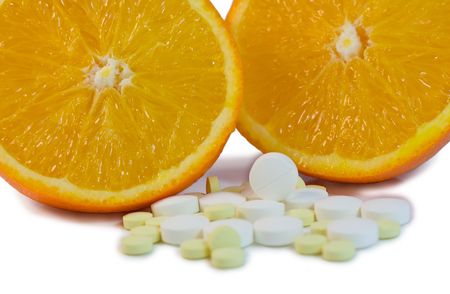 Two half of orange and tablet on a white backgroundの写真素材