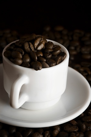 White cup with coffee beans on red backgroundの写真素材