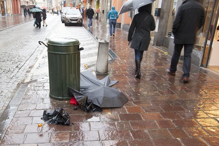 Abandoned broken umbrellas lie in the street. Rainy day.の写真素材