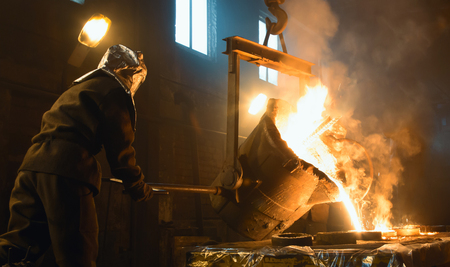 Worker controlling metal melting in furnaces. Workers operates at the metallurgical plant.