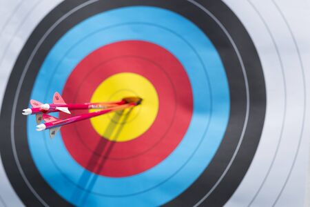 Three arrows from archer hit centre of targetの写真素材