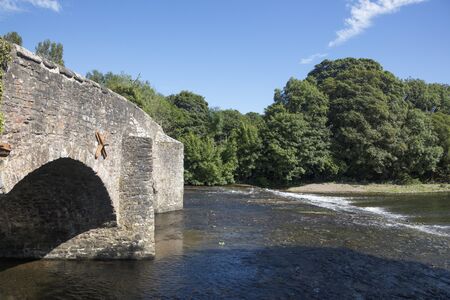 River Exe flows under the medieval stone bridge at Bickley Devon Englandの写真素材