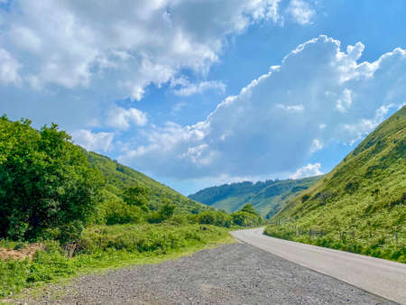 Beautiful hilly landscape of the countryside and road along the Sulby River Valley in the Isle of Man British Islesの写真素材