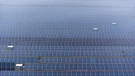 A picture showcasing a vast, contemporary photovoltaic solar farm.