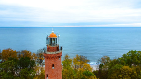Drone-captured image of GÄ…ski Lighthouse, Poland, on a cloudy November day. The serene sea,...
