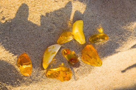 Sunset light brings out the natural radiance of amber on KoÅobrzeg's beach, from milky white to clear honey shades.の写真素材