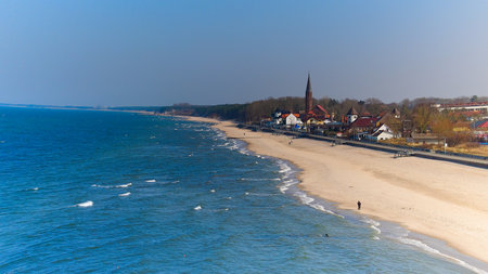 Wide aerial composition showing Sarbinowo's beach, town, and calm Baltic Sea under neutral daylight tones.の写真素材