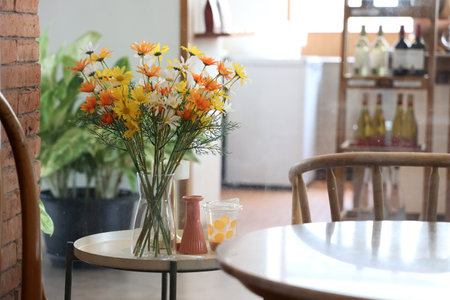 Bouquet of flowers in vase on table in coffee shopの写真素材